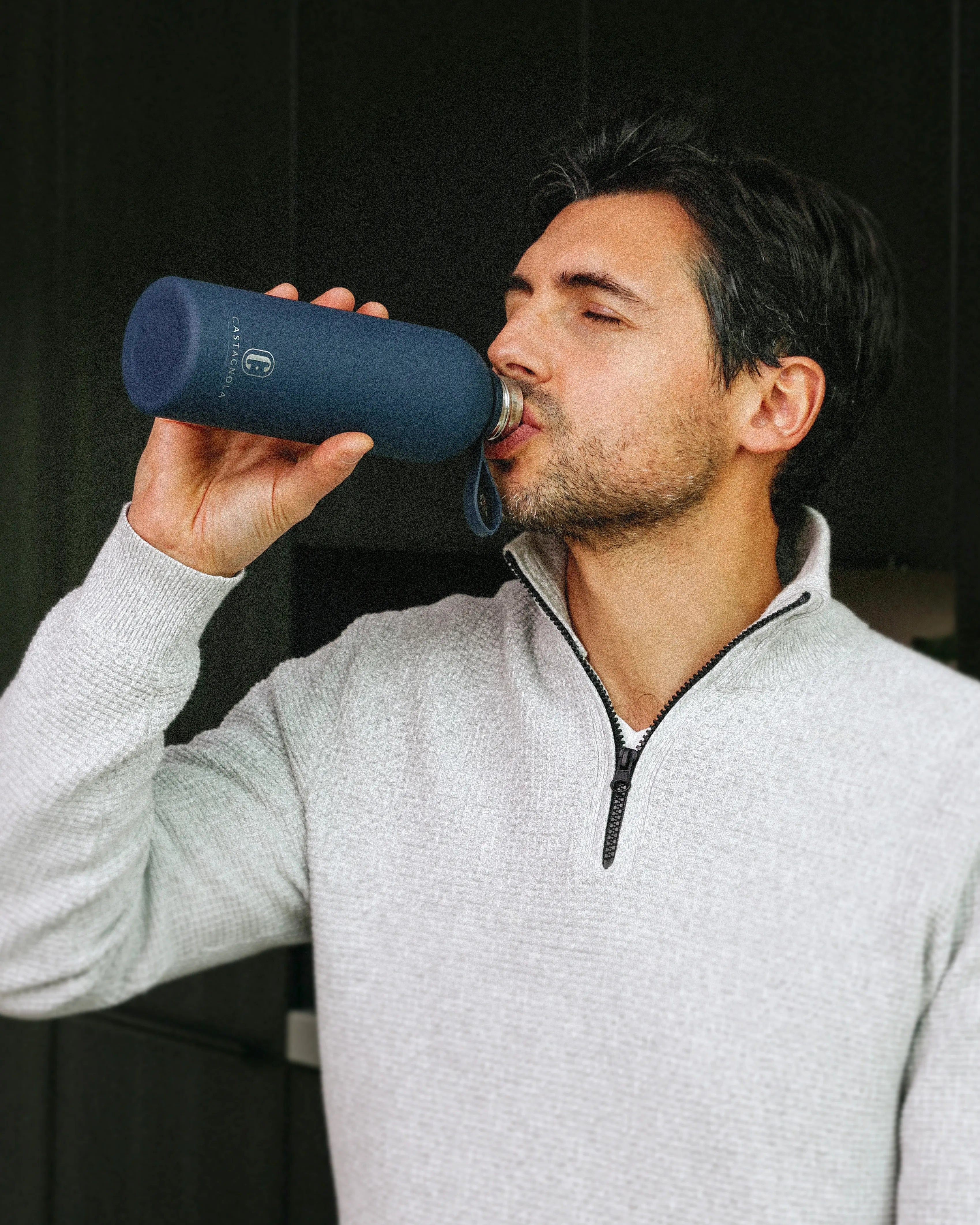 Man drinkt uit een donkerblauwe Castagnola RVS waterfles